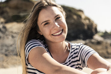 Porträt einer glücklichen jungen Frau am Strand - UUF16445