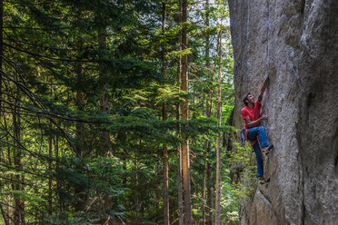 Kletterer erklimmt Felswand in der Nähe von Bäumen, Squamish, Kanada - CUF46922