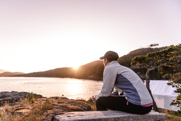 Woman relaxing by lakeside, Johnstone Strait, Telegraph Cove, Canada - CUF46953