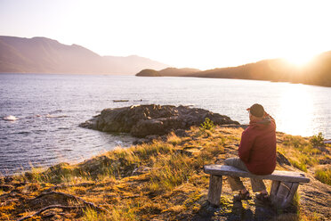 Man relaxing by lakeside, Johnstone Strait, Telegraph Cove, Canada - CUF47056