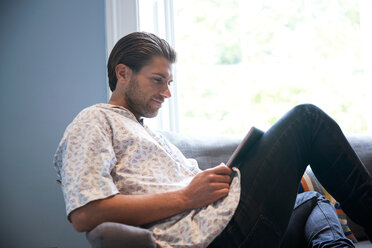 Man using digital tablet on sofa - CUF47069