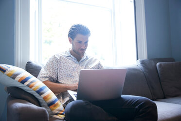 Mann benutzt Laptop auf Sofa - CUF47072