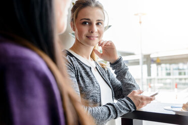 Studentinnen unterhalten sich am Fenster eines Cafés - CUF47135