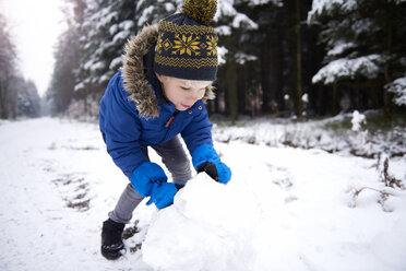 Kleiner Junge baut Schneemann - ABIF01147