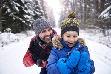 Porträt von Vater und kleinem Sohn zusammen im Winterwald - ABIF01148