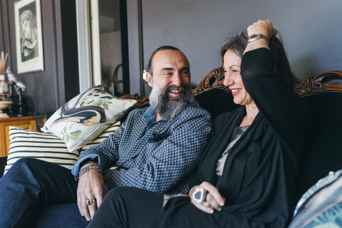 Couple laughing on sofa stock photo