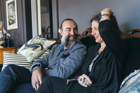 Lachendes Ehepaar auf Sofa, lizenzfreies Stockfoto