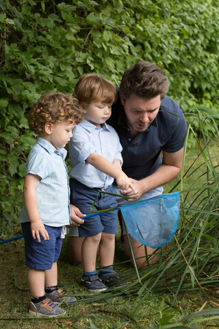 Father and children looking in fishing net stock photo