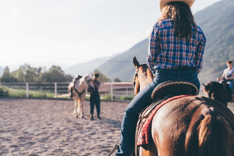 Cowgirl reitet auf einem Pferd in einer ländlichen Reithalle, Primaluna, Trentino-Südtirol, Italien, lizenzfreies Stockfoto