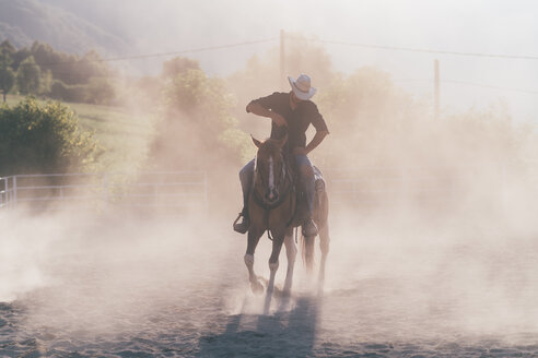 Cowboy reitet auf einem staubigen Reitplatz, Primaluna, Trentino-Südtirol, Italien - CUF47508