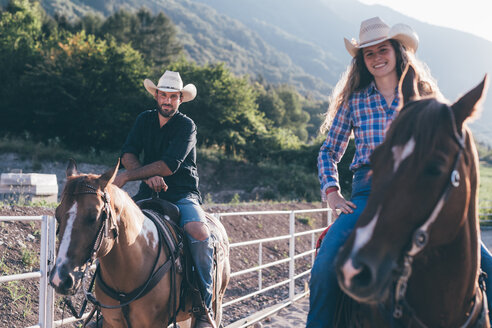 Cowgirl und Junge auf dem Pferderücken in einer Reithalle, Porträt, Primaluna, Trentino-Südtirol, Italien - CUF47512