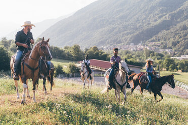 Junge Erwachsene reiten auf Pferden in ländlicher Landschaft, Primaluna, Trentino-Südtirol, Italien - CUF47516