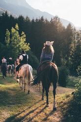 Junge erwachsene Freunde reiten durch den Wald, Rückansicht, Primaluna, Trentino-Südtirol, Italien - CUF47518