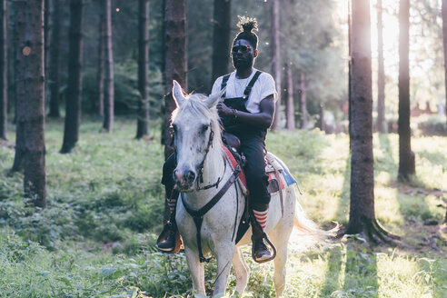 Cooler junger Mann beim Reiten im sonnenbeschienenen Wald, Primaluna, Trentino-Südtirol, Italien - CUF47520