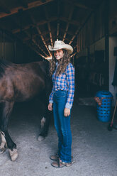 Junges Cowgirl am Stalleingang, Porträt - CUF47536