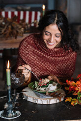 Young woman eating fresh salad at vintage table - CUF47566