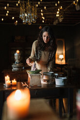 Young woman at vintage table serving risotto - CUF47580