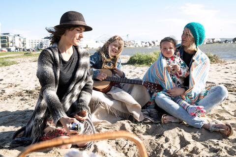 Schwestern und ihre Kinder genießen den Strand, lizenzfreies Stockfoto