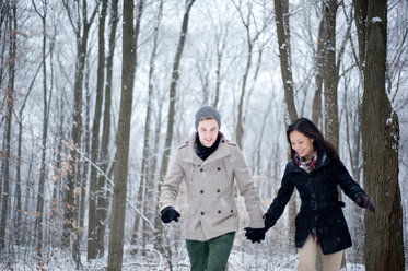 Junges Paar spaziert Hand in Hand im verschneiten Wald, Ontario, Kanada - CUF47822