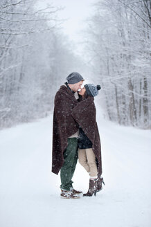 Romantisches junges Paar, das sich im verschneiten Wald küsst, Ontario, Kanada - CUF47828