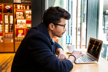 Geschäftsmann mit Laptop in einem Cafe - CUF47884