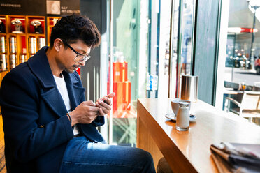 Geschäftsmann benutzt Smartphone in einem Cafe - CUF47885
