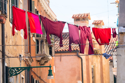 Rote und rosafarbene Kleidung auf Wäscheleinen vor traditionellen Häusern, Venedig, Veneto, Italien - CUF47887