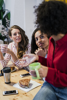 Drei Frauen unterhalten sich am Tisch - GIOF05483