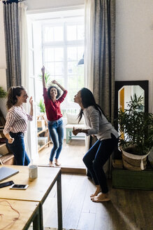 Drei Frauen feiern zu Hause eine Party und tanzen - GIOF05549