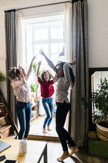 Drei Frauen feiern zu Hause eine Party und tanzen - GIOF05550