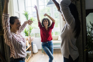 Drei Frauen feiern zu Hause eine Party und tanzen - GIOF05552