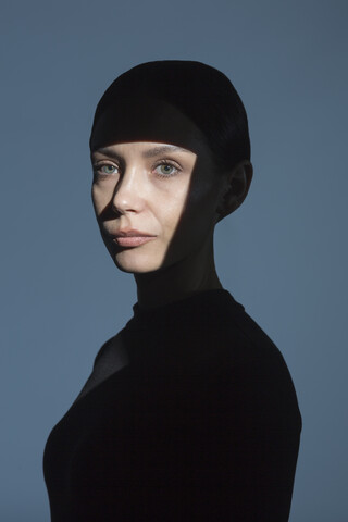 Porträt einer Frau mit Schatten und Licht im Gesicht, lizenzfreies Stockfoto