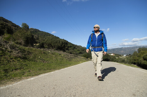 Spanien, Andalusien, Tarifa, Mann auf Wanderschaft, der auf der Straße läuft, lizenzfreies Stockfoto