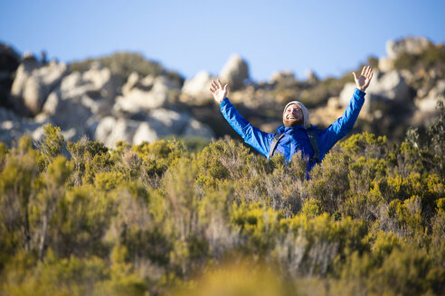 Spanien, Andalusien, Tarifa, glücklicher Mann auf einer Wandertour in den Bergen, der jubelt - KBF00413