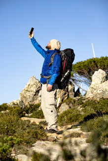 Spanien, Andalusien, Tarifa, Mann beim Wandern in den Bergen, der ein Selfie macht - KBF00420