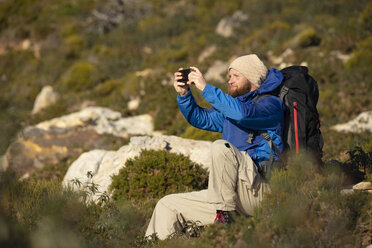 Spain, Andalusia, Tarifa, man on a hiking trip sitting down taking a selfie - KBF00422