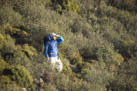 Spanien, Andalusien, Tarifa, Mann auf Wanderschaft in den Bergen mit Blick auf die Aussicht, lizenzfreies Stockfoto