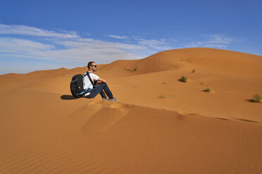 Morocco, man sitting on desert dune looking at view - EPF00546