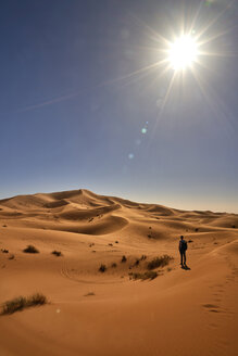 Morocco, Sahara, man with backpack standing on desert dune looking at view - EPF00550