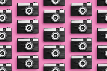 Plastic photo cameras organized in a row over pink background - DRBF00127