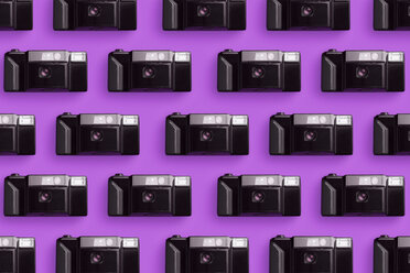 Plastic photo cameras organized in a row over pink background - DRBF00131