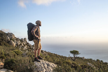 Spanien, Andalusien, Tarifa, Mann auf Wanderschaft an der Küste mit Blick auf die Aussicht - KBF00450