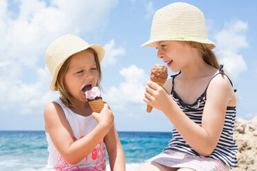 Two girls eating ice cream cone on beach, Scopello, Sicily, Italy - CUF47900