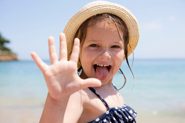 Girl in sunhat sticking out her tongue, portrait, Scopello, Sicily, Italy - CUF47904