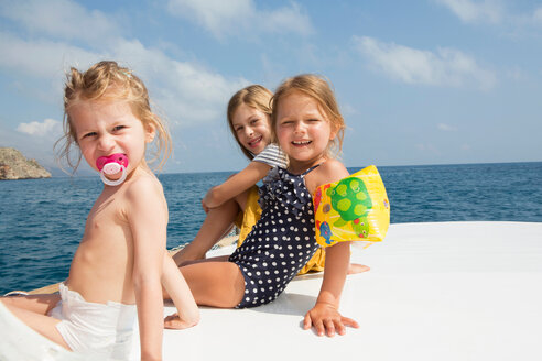 Drei süße Mädchen sitzen auf einem Boot, Porträt, Castellammare del Golfo, Sizilien, Italien - CUF47906