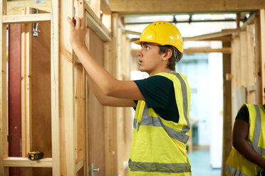 Männliche Hochschulstudenten bauen in einem College-Workshop ein Holzgerüst - CUF48008