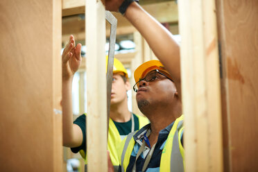 Male higher education students building wooden framework in college workshop - CUF48010