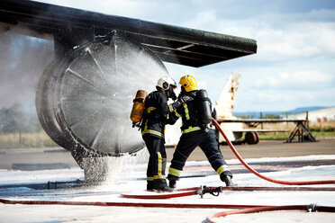 Feuerwehrleute beim Löschen eines Feuers in einem alten Trainingsflugzeug, Darlington, UK - CUF48147