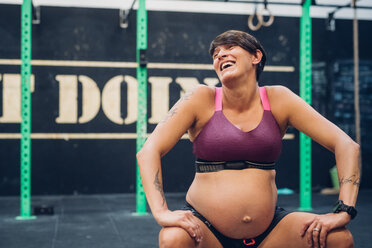 Pregnant woman laughing in gym - CUF48218