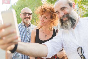 Mid erwachsene Frau und männliche Freunde nehmen Smartphone selfie auf Stadtstraße - CUF48240